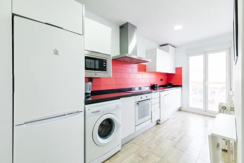 a kitchen with white cabinets and a washer and dryer at Apartamento Neptuno in Granada