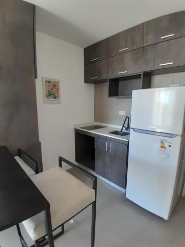 uma cozinha com um frigorífico branco, uma mesa e cadeiras em Elegancia y Confort G&A Rent (308) em Ezeiza