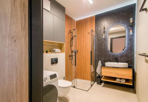 a bathroom with a toilet and a sink and a shower at MTP/ZOO Prestige Apartments in Poznań