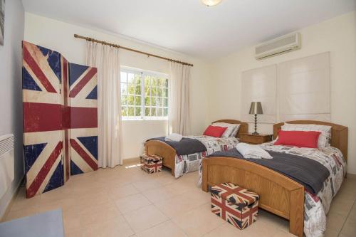 - une chambre avec 2 lits et un drapeau mural dans l'établissement Villa Caravela, à Almancil