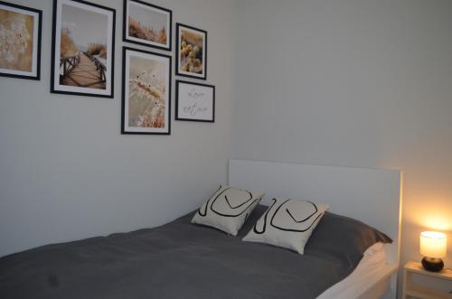 een slaapkamer met een bed met foto's aan de muur bij Apart city break apartament in Świebodzice
