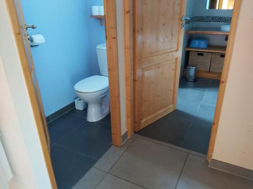 a small bathroom with a toilet and a door at La Prairie in Noyers-sur-Jabron