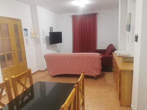 a living room with a couch and a bed in a room at Chalet Islantilla "Costa de la Luz" in Lepe