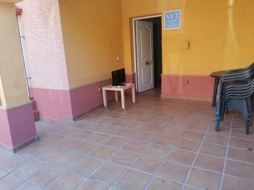 a room with a tv and a table and chairs at Chalet Islantilla "Costa de la Luz" in Lepe