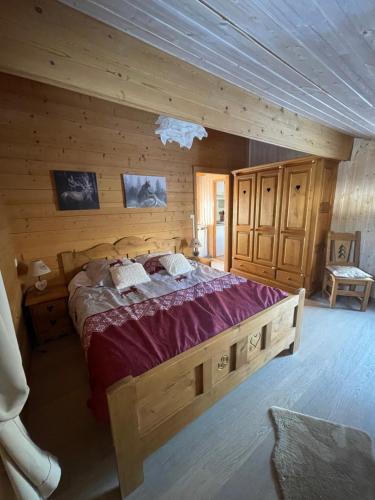 - une chambre avec un grand lit dans une cabane en rondins dans l'établissement Les Cachettes du Hérisson - Le Choupisson, à Le Frasnois