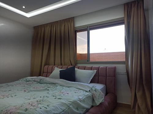 - une chambre avec un lit et une grande fenêtre dans l'établissement Luxueuse Villa, à Béni Mellal