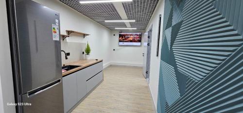 a kitchen with a refrigerator and a tv on a wall at Ocean hostel in Osh