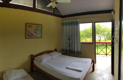 sypialnia z łóżkiem i dużym oknem w obiekcie Chalé Azul w mieście Tamandaré