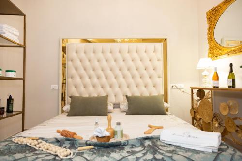 a bedroom with a large bed with a large headboard at Femme noir Boutique Apartament Fitness e spa in Caserta