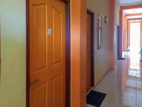 eine orangefarbene Tür im Flur eines Gebäudes in der Unterkunft HOME STAY HARAPAN 
