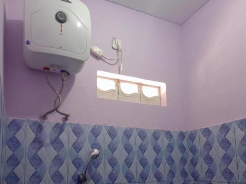 ein Bad mit einem Haartrockner an der Wand in der Unterkunft HOME STAY HARAPAN 