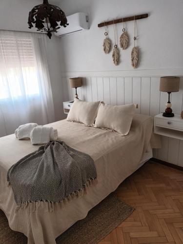 a bedroom with a bed with white walls and a chandelier at Dos Ambientes Deluxe Concordia Centro in Concordia