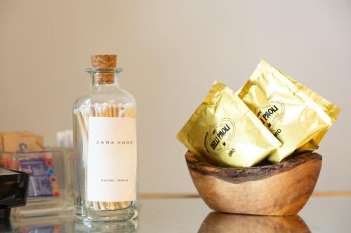 a bottle of alcohol next to a bowl of chips at Femme noir Boutique Apartament Fitness e spa in Caserta