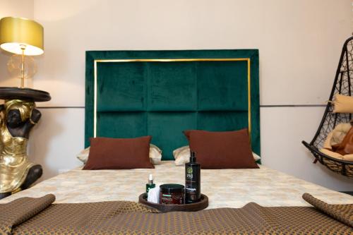 a bedroom with a bed with a green headboard at Femme noir Boutique Apartament Fitness e spa in Caserta