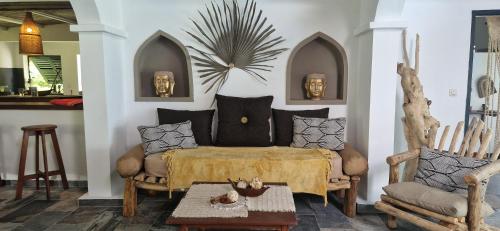 a living room with a couch and a table at La VILLA BORAHA 300m2 PROPRIÉTÉ ENTIERE en bord de plage PISCINE PRIVEE Cuisine TV Wifi in Sainte Marie