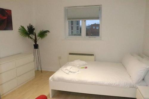 a bedroom with a white bed and a window at Snug 2BR Apt. Free Parking, 4KTV in London