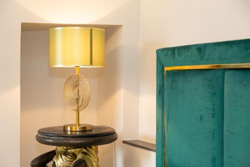 a lamp on a table next to a bed at Femme noir Boutique Apartament Fitness e spa in Caserta