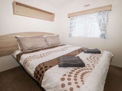 a bedroom with a bed with two pillows on it at 24 Winchelsea Sands Holiday Park in Winchelsea