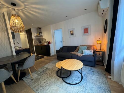a living room with a blue couch and a table at "Le petit bonlieu" au centre ville et à 300 m du lac in Annecy