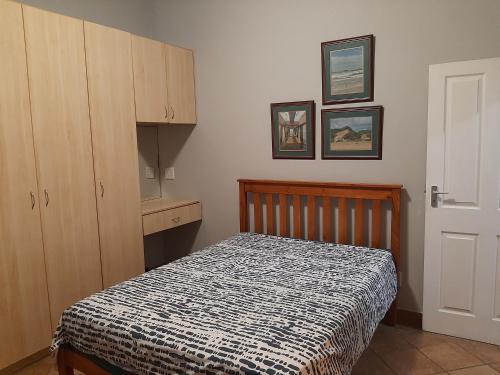 a small bedroom with a bed and a cabinet at Britsies @ Sea in Mossel Bay