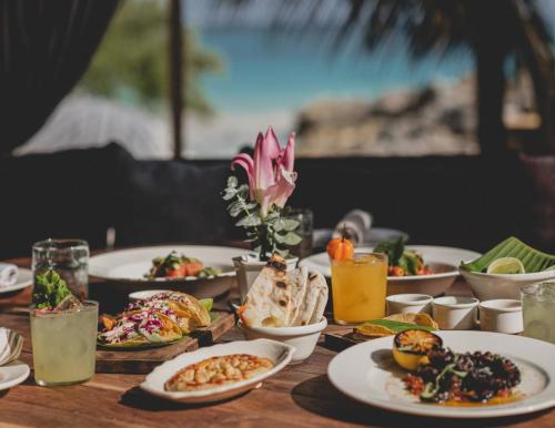 a table topped with plates of food and drinks at Casa Gitano in Tulum