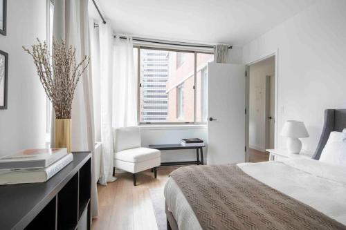 a white bedroom with a bed and a window at Brooklyn bridge view residence in New York