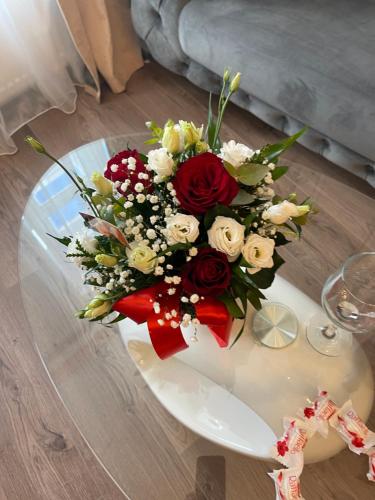 un bouquet di fiori rossi e bianchi su un tavolo di Luxuroom a Sibiu