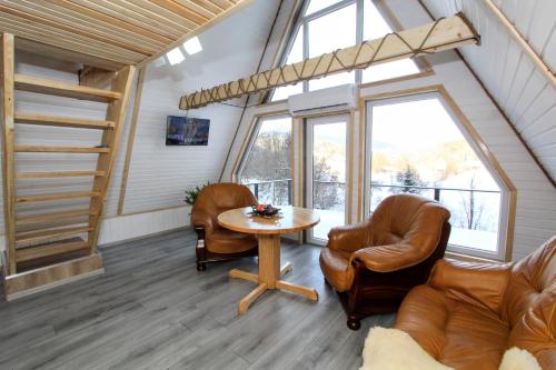 uma sala de estar com uma mesa e cadeiras e uma escadaria em Cottage "A-FRAME romantic house" em Yaremche