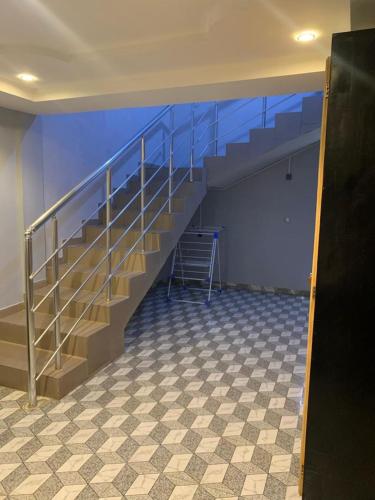 escalera de metal en una habitación con suelo de baldosa en Maison personnelle d'une chambre salon meublé, en Cotonou
