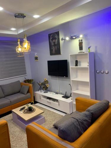 sala de estar con sofá y TV en Maison personnelle d'une chambre salon meublé, en Cotonou