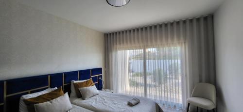 Un dormitorio con una cama y una ventana grande. en Villa Silver Coast, en Nadadouro