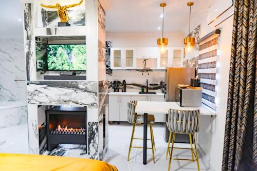eine Küche und ein Wohnzimmer mit einem Kamin und einem Tisch in der Unterkunft Homes of Ace Diamond in Pretoria