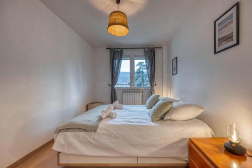 een slaapkamer met een wit bed en een raam bij Le Boisé - Centre Ville / Calme in Grenoble