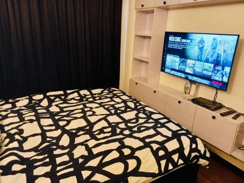 - une chambre avec un lit et une télévision à écran plat dans l'établissement Rm’s Inn, à Manille