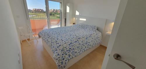 Schlafzimmer mit einem Bett und Blick auf einen Balkon in der Unterkunft Luxurious modern holiday flat on Mar Menor Golf Resort in Torre-Pacheco