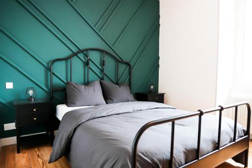 a bedroom with a bed with a green wall at La Villa Hortensia in Jungholtz