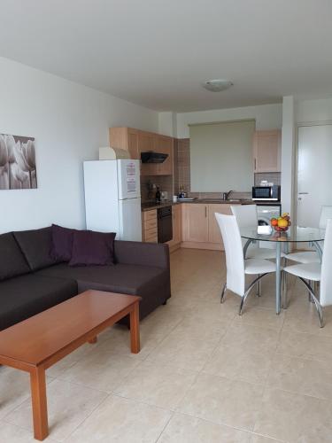 a living room with a couch and a table and a kitchen at Holiday Apartment with Sea View (0002913) in Paralimni