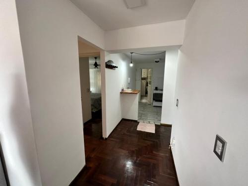 une chambre vide avec une cuisine et un couloir revêtu de parquet dans l'établissement Departamento Pancho Ramirez, à Concordia