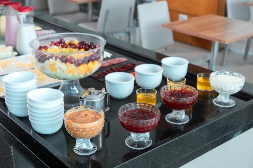 a table topped with glasses and bowls of fruit at ibis Presidente Prudente Manoel Goulart in Presidente Prudente