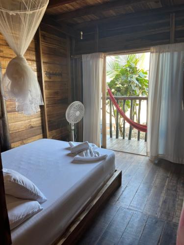 a bedroom with a bed and a large window at the mompe beach hostal in La Poza