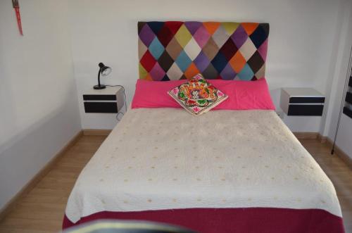 Bett mit farbenfrohem Kopfteil in einem Zimmer in der Unterkunft Cleopatra in Buenos Aires