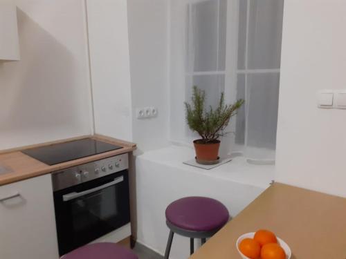 a kitchen with a stove and a table with a bowl of oranges at Fantomas*** N4 City Center Apartments 3 Bedroom + Living room in Szombathely
