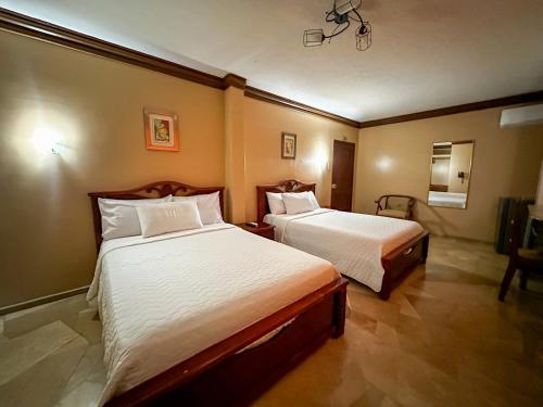 a room with two beds in a hotel room at Hotel Bucaneiro in Manta