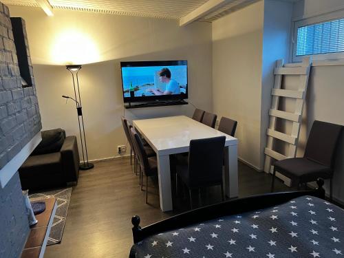 a room with a table and a tv on the wall at Heaven in Pori