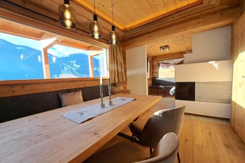 uma sala de jantar com uma mesa de madeira e cadeiras em Chalet - Das Schrofen em Ramsau im Zillertal
