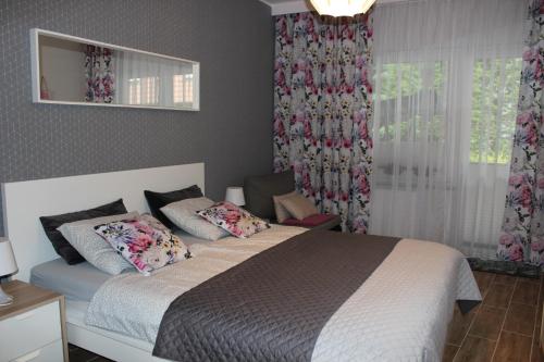 a bedroom with a bed and a window with curtains at Sunny Adventure Baltic Apartament in Pobierowo