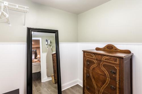 um quarto com uma cómoda de madeira e um espelho em Cozy Apartment in Downtown Neighborhood em Columbia