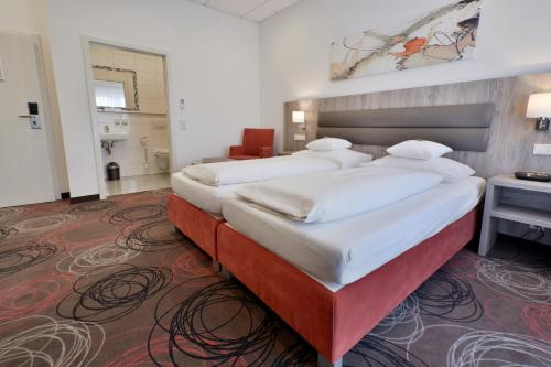 two beds in a hotel room with at Hotel Engelhorn in Leimen