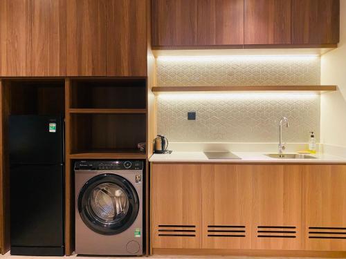 a kitchen with a washing machine and a sink at Apec Mandala Condotel Sea View Comhomes Phú Yên in Tuy Hoa