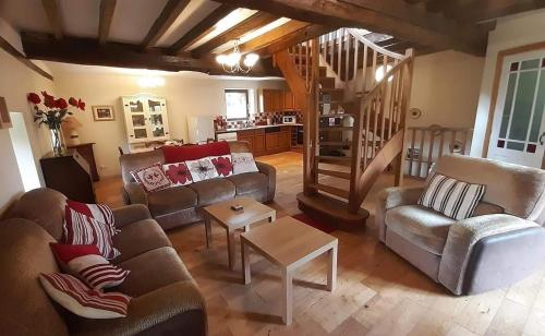 - un salon avec deux canapés et un escalier dans l'établissement Le Moulin des Hiboux - Gite avec salle de jeux games room, à Fontenay